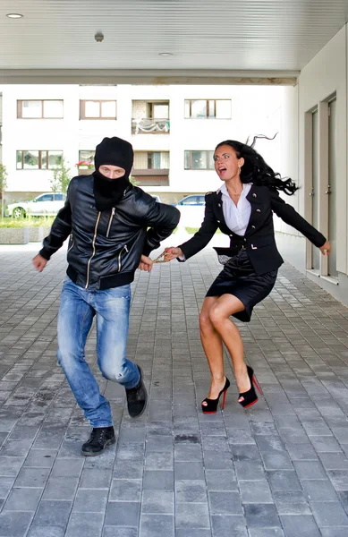 Bandit stealing businesswoman bag in the street — Stock Photo, Image