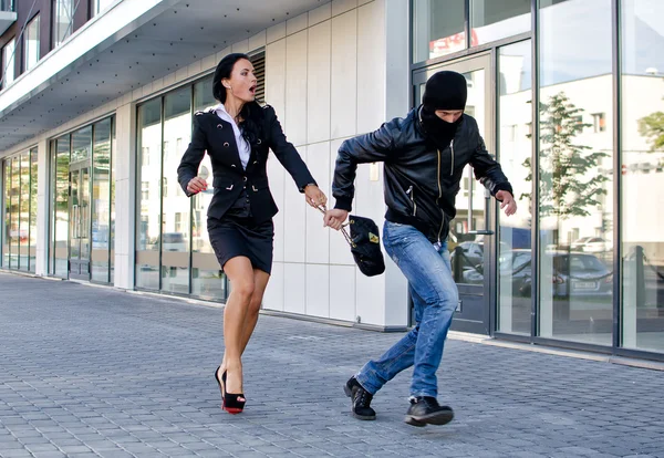 Bandit stealing businesswoman bag in the street — Stock Photo, Image