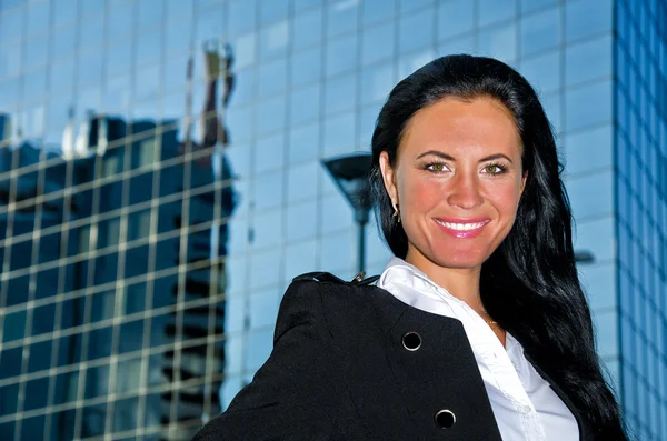 Retrato de una mujer bonita posando cerca de un moderno edificio de oficinas —  Fotos de Stock