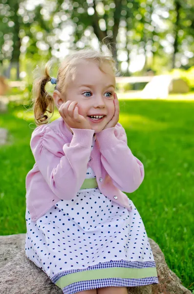 Ritratto di una bambina adorabile seduta nel parco — Foto Stock