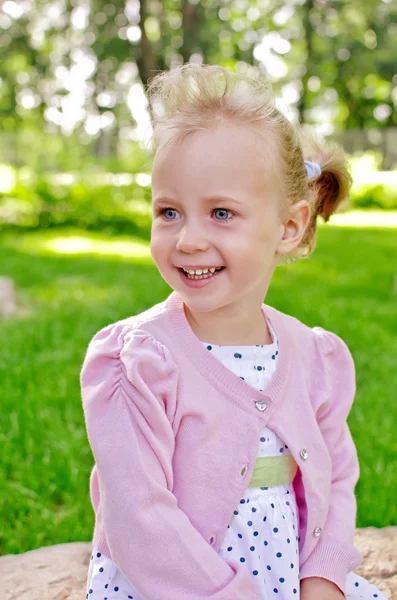 Portrait d'une petite fille charmante assise dans le parc — Photo