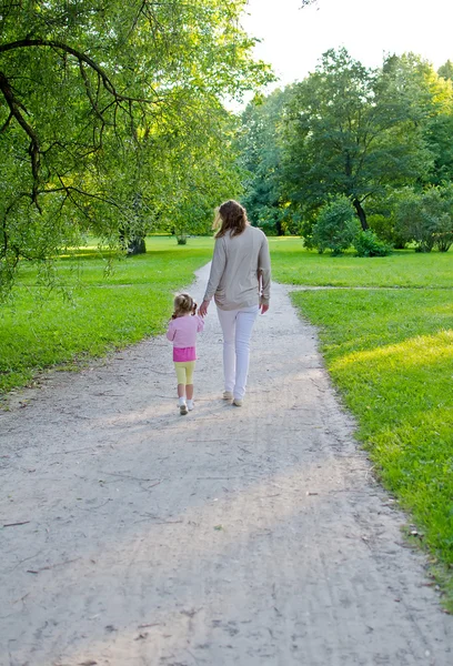 Mãe e criança caminham no parque. Visão traseira — Fotografia de Stock