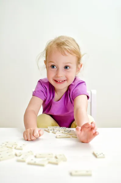 可爱的小女孩，在桌上玩多米诺骨牌 — 图库照片