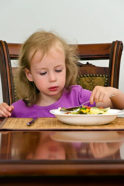 Cute dziewczynka jedzenie sałatka z łyżeczką — Zdjęcie stockowe