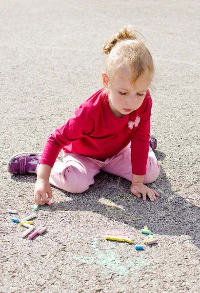 Little girl drawing with chalk on asphalt — Stock Photo, Image