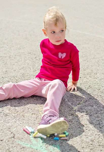 Cute little girl sitting on asphalt — Stock Photo, Image