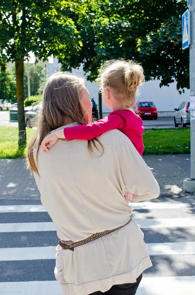 Мать и ребенок переходят дорогу. Вид сзади . — стоковое фото