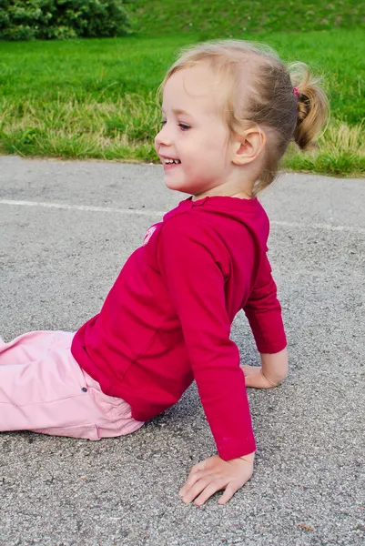 Schattig klein meisje, zittend op asfalt — Stockfoto