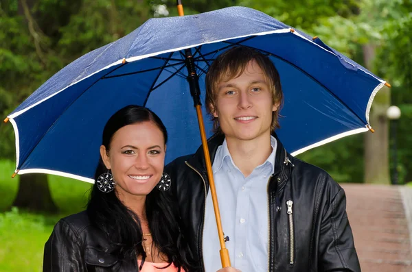 Retrato de jovem casal sob guarda-chuva no parque — Fotografia de Stock