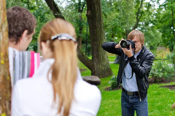 Fotograf ma zdjęcie młodej pary na zewnątrz — Zdjęcie stockowe