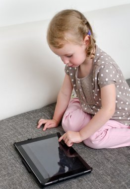 tablet bilgisayar kullanarak sevimli küçük kız