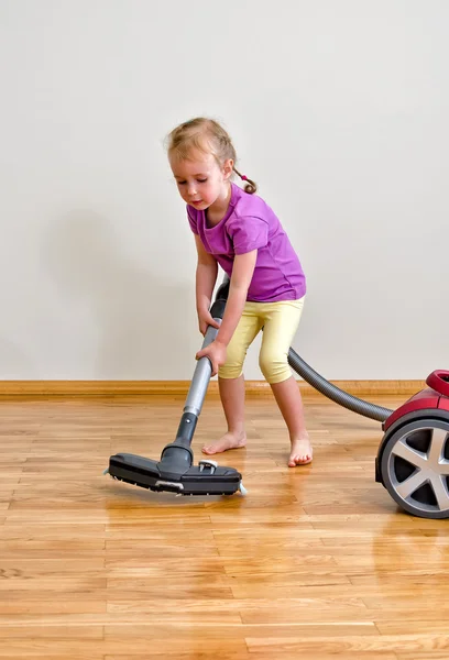 Linda niña limpieza piso con aspiradora — Foto de Stock