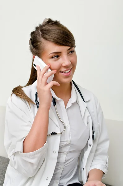 Young female doctor talking on phone — Stock Photo, Image