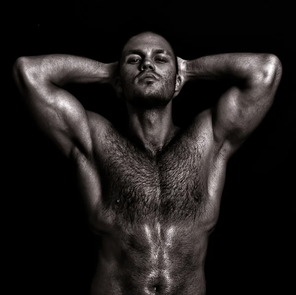 Nackter muskulöser Kerl, der mit den Händen hinter dem Kopf posiert. schwarz-weiß — Stockfoto
