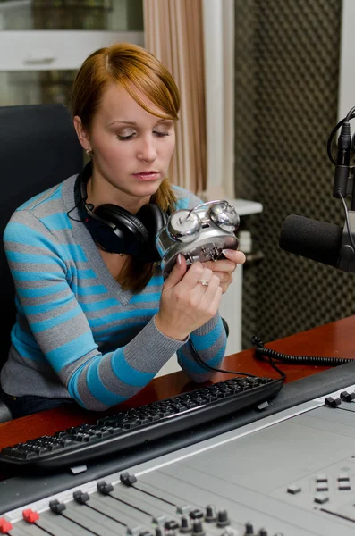 Retrato de fêmea dj stting na frente de um microfone no rádio com ala — Fotografia de Stock