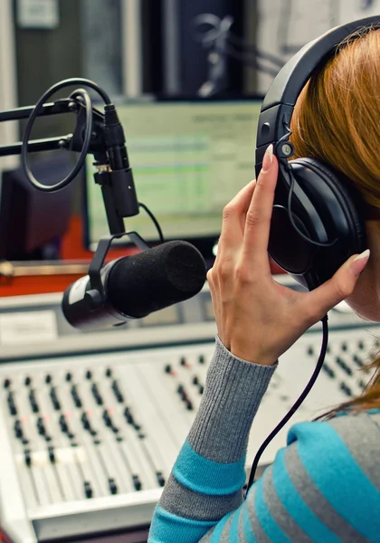 Achteraanzicht van vrouwelijke dj werken voor een microfoon op de radio — Stockfoto