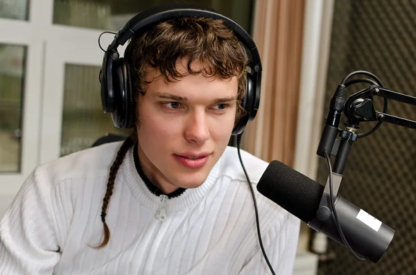 Retrato de dj masculino trabajando delante de un micrófono en la radio — Foto de Stock