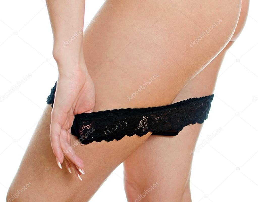 Girl taking off her black panties. Isolated on white.