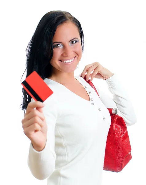 Mulher sorridente com cartão de crédito vermelho e saco. Isolado em branco . — Fotografia de Stock