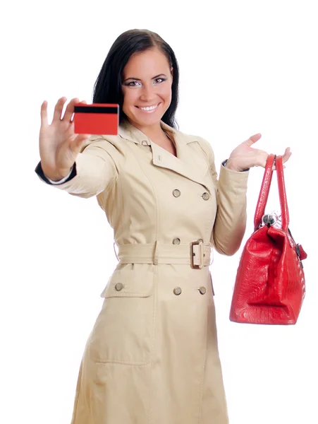 Lächelnde Frau mit roter Kreditkarte und Tasche. isoliert auf weiß. — Stockfoto