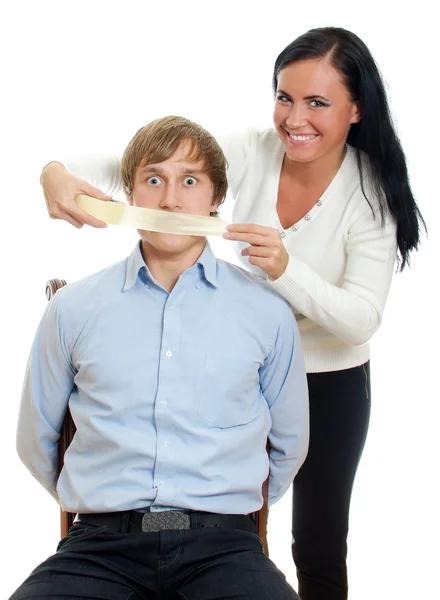 Женщина накладывает ленту на рот мужчины — стоковое фото