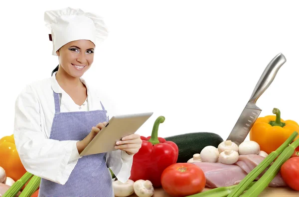 Jefe de cocina con la tableta de PC y verduras en el fondo. Aislado sobre blanco . —  Fotos de Stock