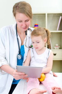 çocuk doktoru ve tablet bilgisayar kullanan küçük kız