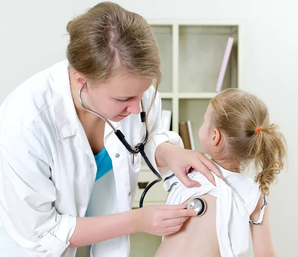 Doctora examinando a una niña con estetoscopio —  Fotos de Stock