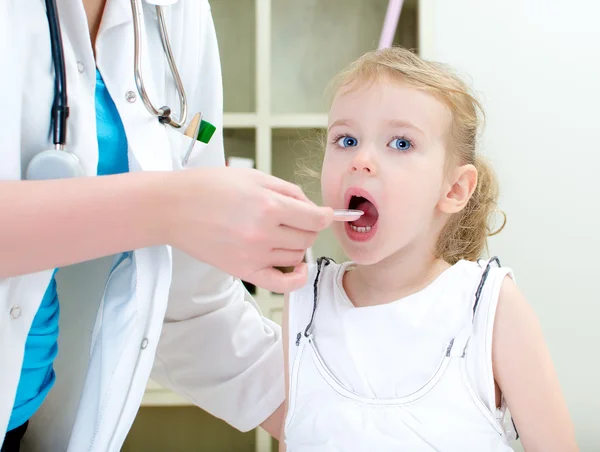 Nettes kleines Mädchen besucht Kinderarzt und nimmt Medizin — Stockfoto