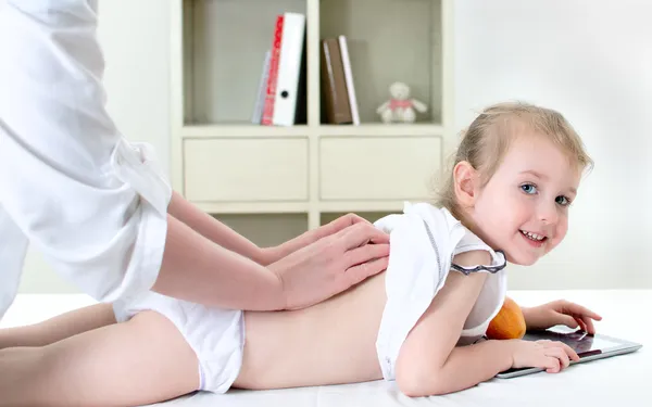 Массажистка делает массаж маленькой девочке — стоковое фото