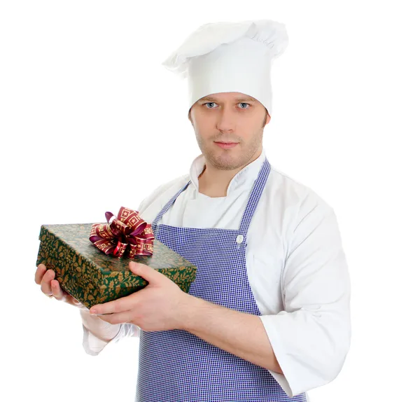 Junger Koch hält Geschenkbox in der Hand. isoliert auf weiß — Stockfoto