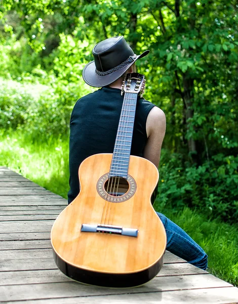 Bagudsigten ensom mand med guitar - Stock-foto