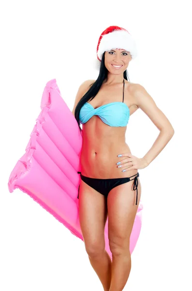 Young woman in bikini and christmas hat holding inflatable mattress. Isolated on white — Stock Photo, Image