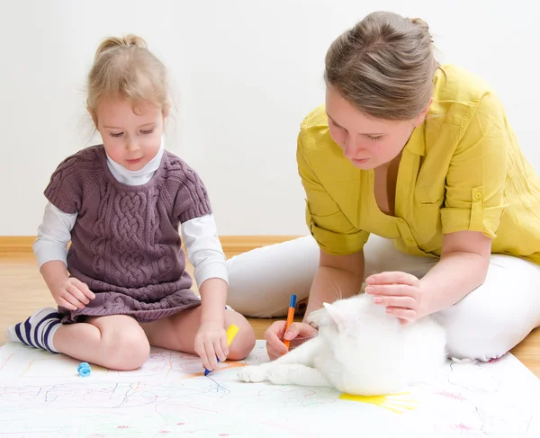 Young woman and little girl drawing together sitting on the floor — Stock Photo, Image