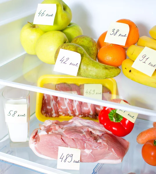 Frigorífico aberto cheio de frutas, legumes e carne com calorias marcadas — Fotografia de Stock