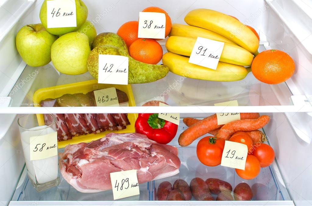 Open fridge full of fruits, vegetables and meat with marked calories