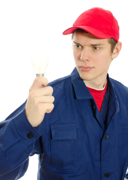 Joven electricista en uniforme con bombilla. Aislado sobre blanco — Foto de Stock