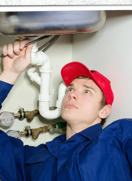 Fontanero en uniforme de reparación de tuberías en la casa . — Foto de Stock