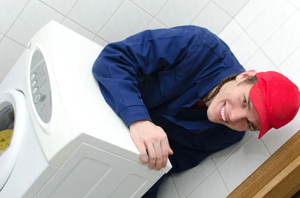 Young worker repairing washing machine — Stock Photo, Image