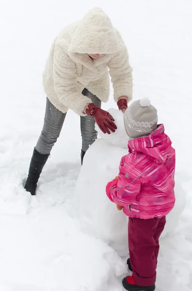 Madre e hijo haciendo muñeco de nieve —  Fotos de Stock