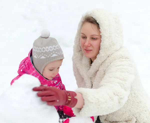 Mãe e criança fazendo boneco de neve — Fotografia de Stock