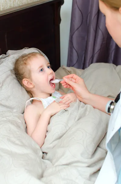 Pediatrician visiting sick child at home and giving medicine — Stock Photo, Image