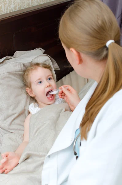 Pediatrician visiting sick child at home and giving medicine — Stock Photo, Image