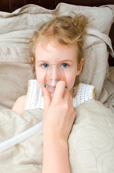 Porträtt av lilla flickan i sängen med inhalator mask i ansiktet — Stockfoto