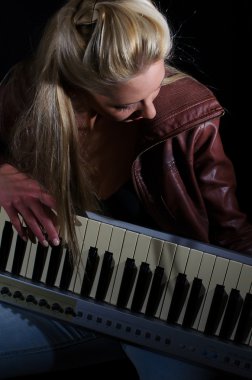 Sexy lady sutyen ve deri ceket siyah arka plan üzerinde synthesizer ile poz