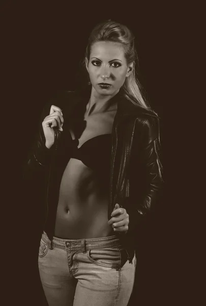 Sexy dama en sujetador y jeans posando sobre fondo negro — Foto de Stock