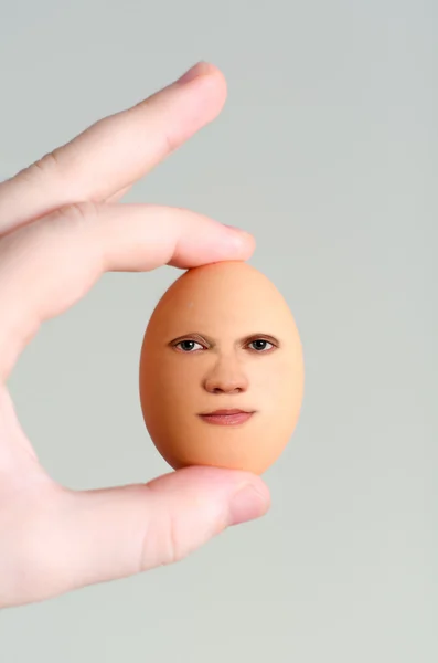 人間の顔に卵を持っている男性の手 — ストック写真
