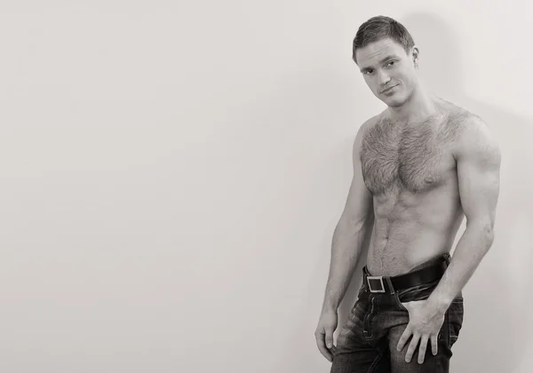 Молодий красивий хлопець в джинсах з голим торсом на стіні — стокове фото