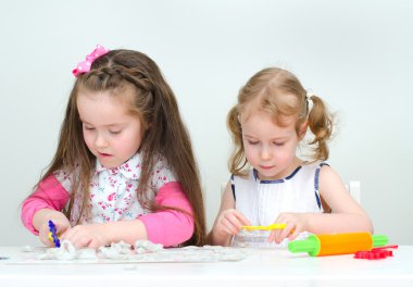 twee kleine meisjes beeldhouwen met behulp van klei