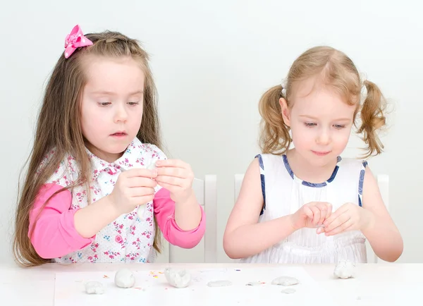 Two little girls sculpting using clay — Stock Photo, Image